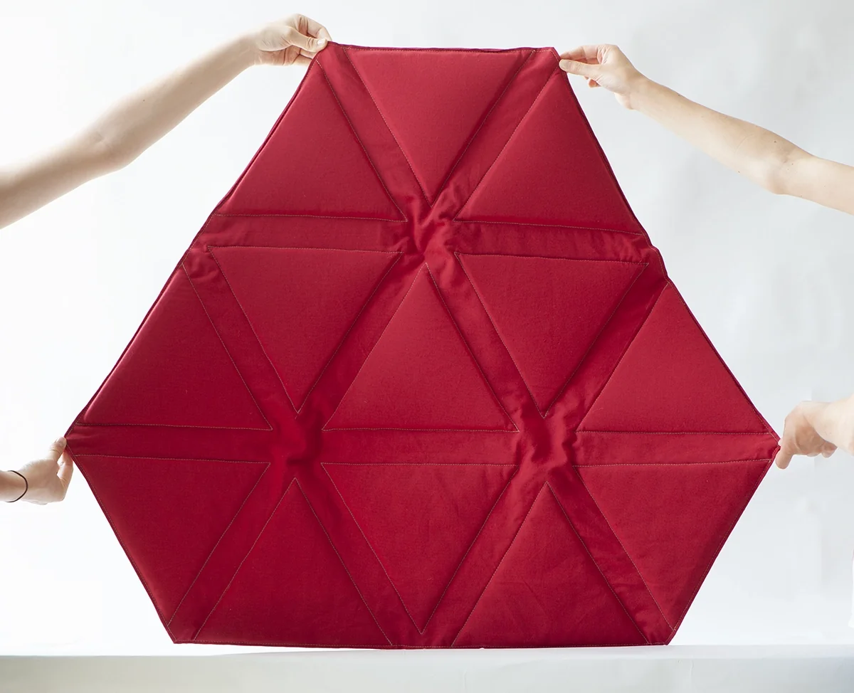 Surface textile rouge à facettes triangulaires déployée
