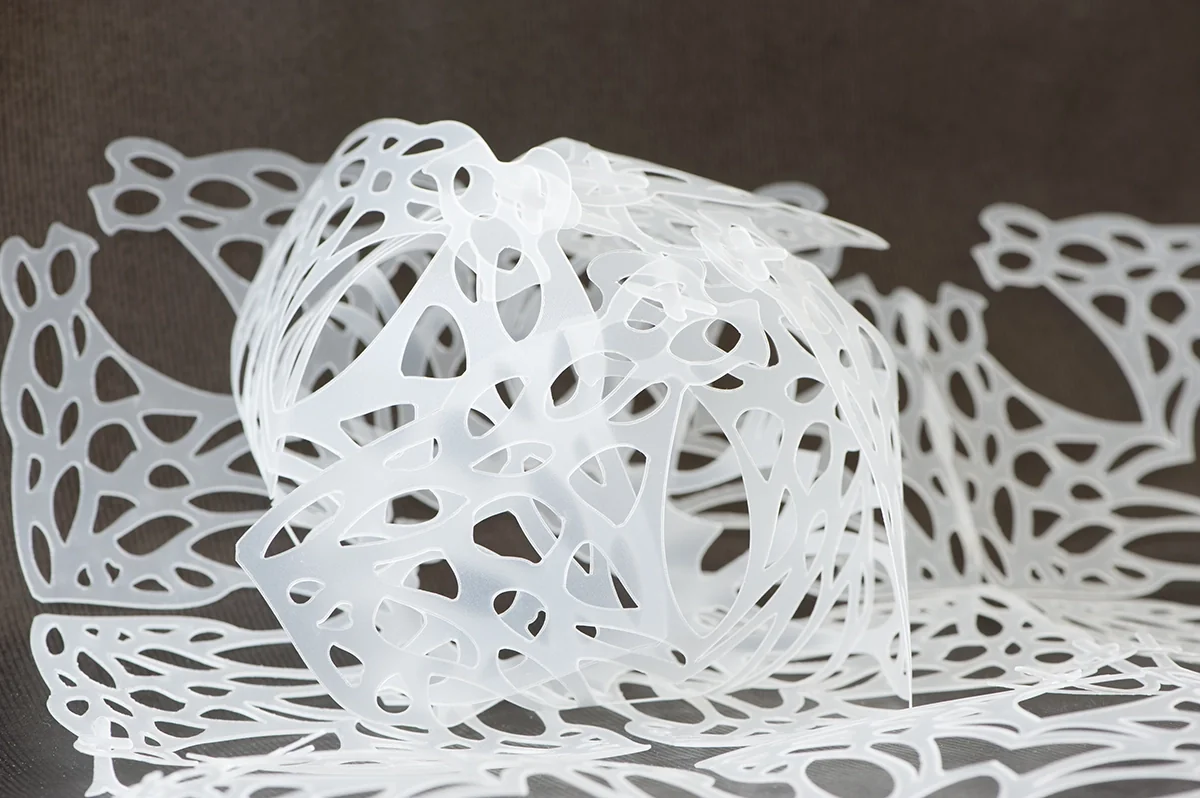 Dentelle plastique blanche découpée, enroulée sur elle-même