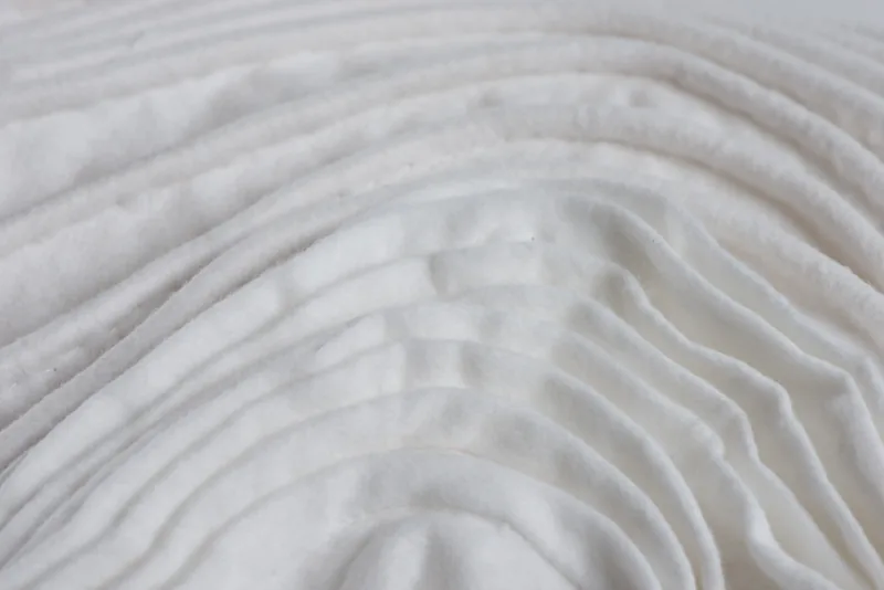 DMA 2014 - TextilePromenade dans un paysage : des panneaux de papier plissé et de laine feutrée, entre ombres et lumières.