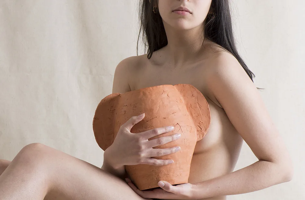 Vase en terre cuite rouge tenu contre le corps