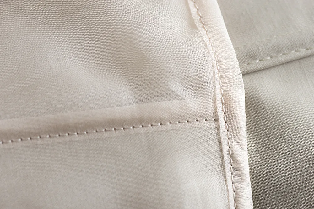 Détail : coutures et plis sur la toile beige