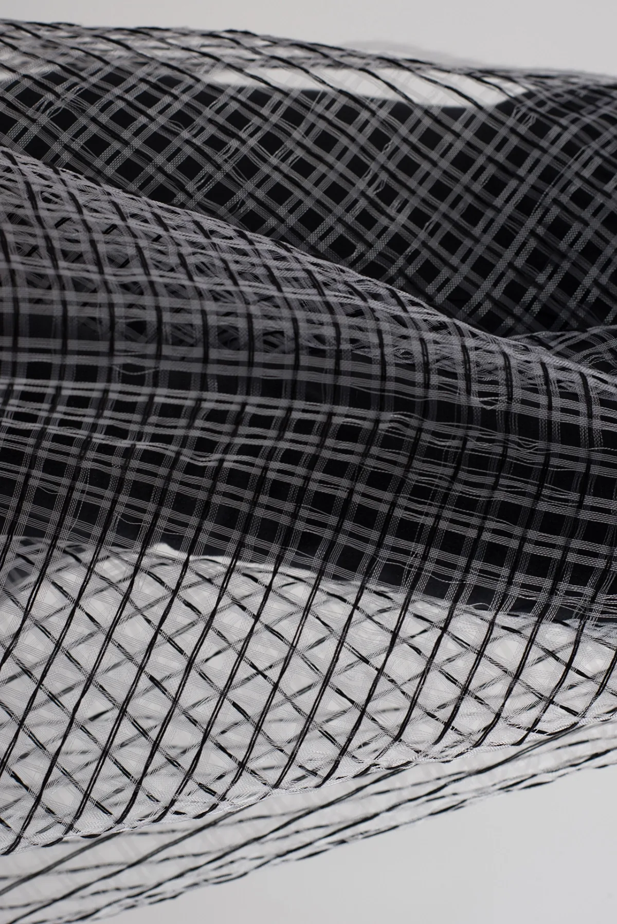 Détail d’une surface filaire : trame textile noire en quadrillage