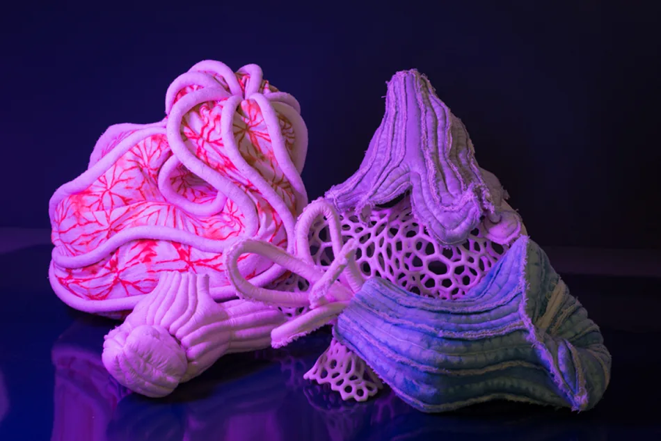 Créatures textiles sous lumière ultraviolette, reflets roses et violets