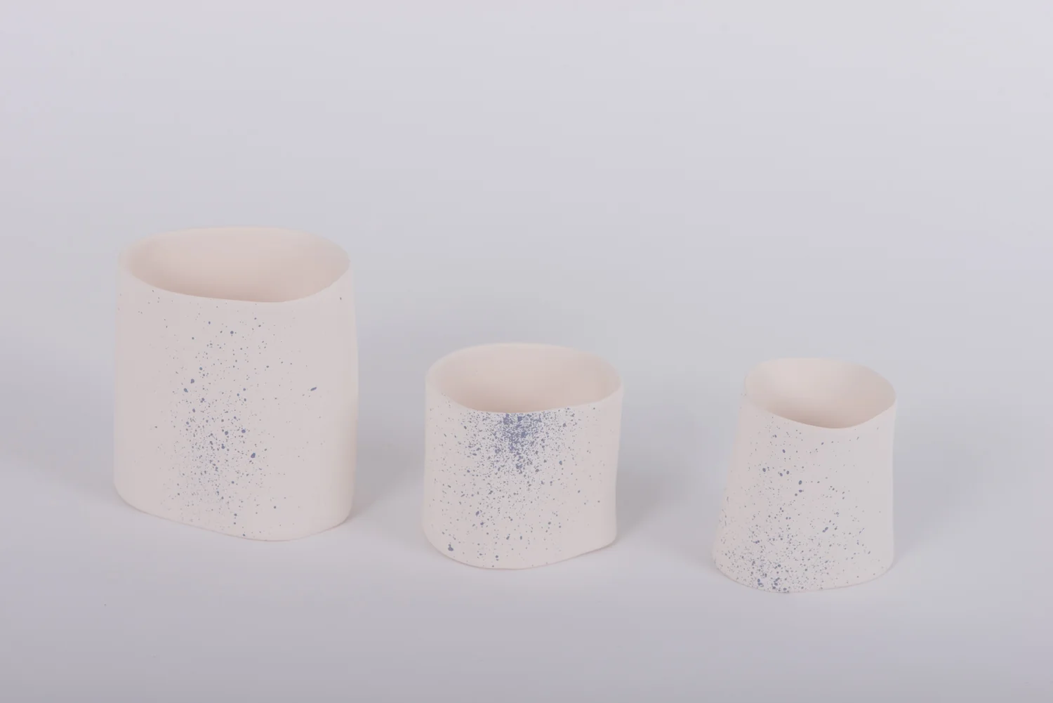 Trois pots en céramique blanche mouchetés de bleu