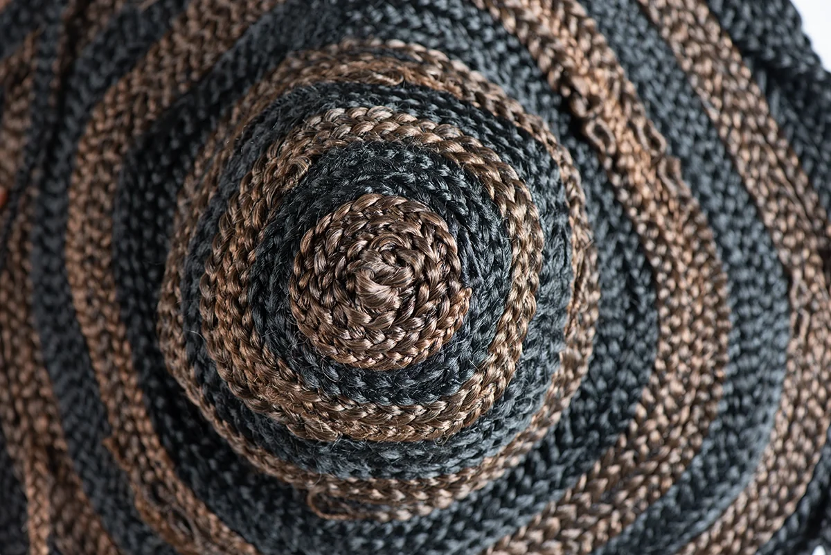 Détail d’une coiffe : spirale de tresses brunes, noires et bleu-gris