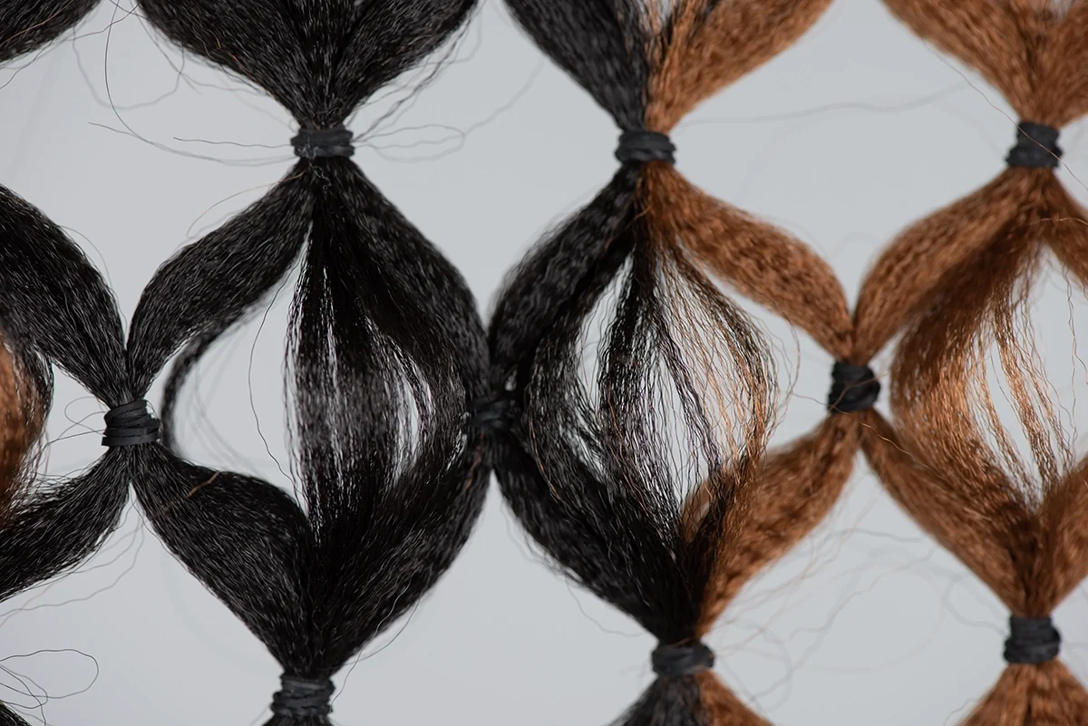 Filet de tresses noires et brunes noué en losanges