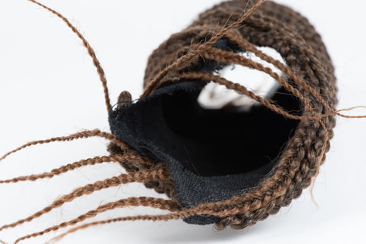 Coiffe en volume : coque noire bordée de tresses brunes