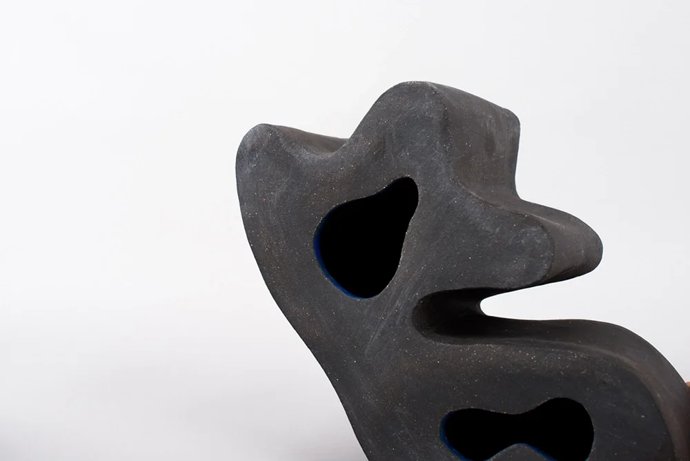 Sculpture en céramique noire aux courbes organiques percées
