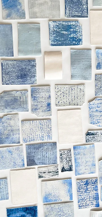 Plaquettes de porcelaine aux écritures bleues illisibles, disposées en mosaïque