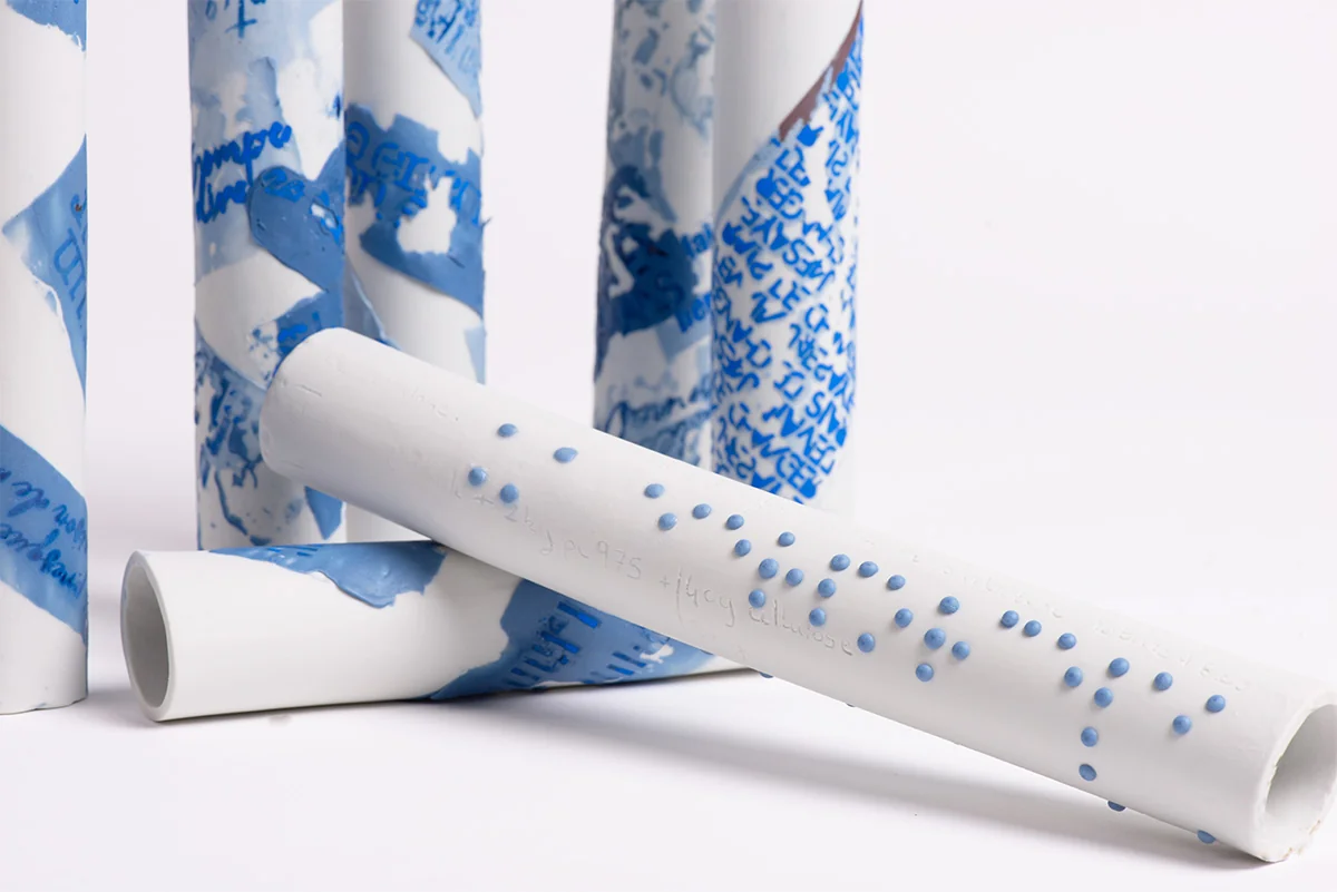 Tubes de porcelaine blanche couverts d’écritures bleues, dressés et couchés
