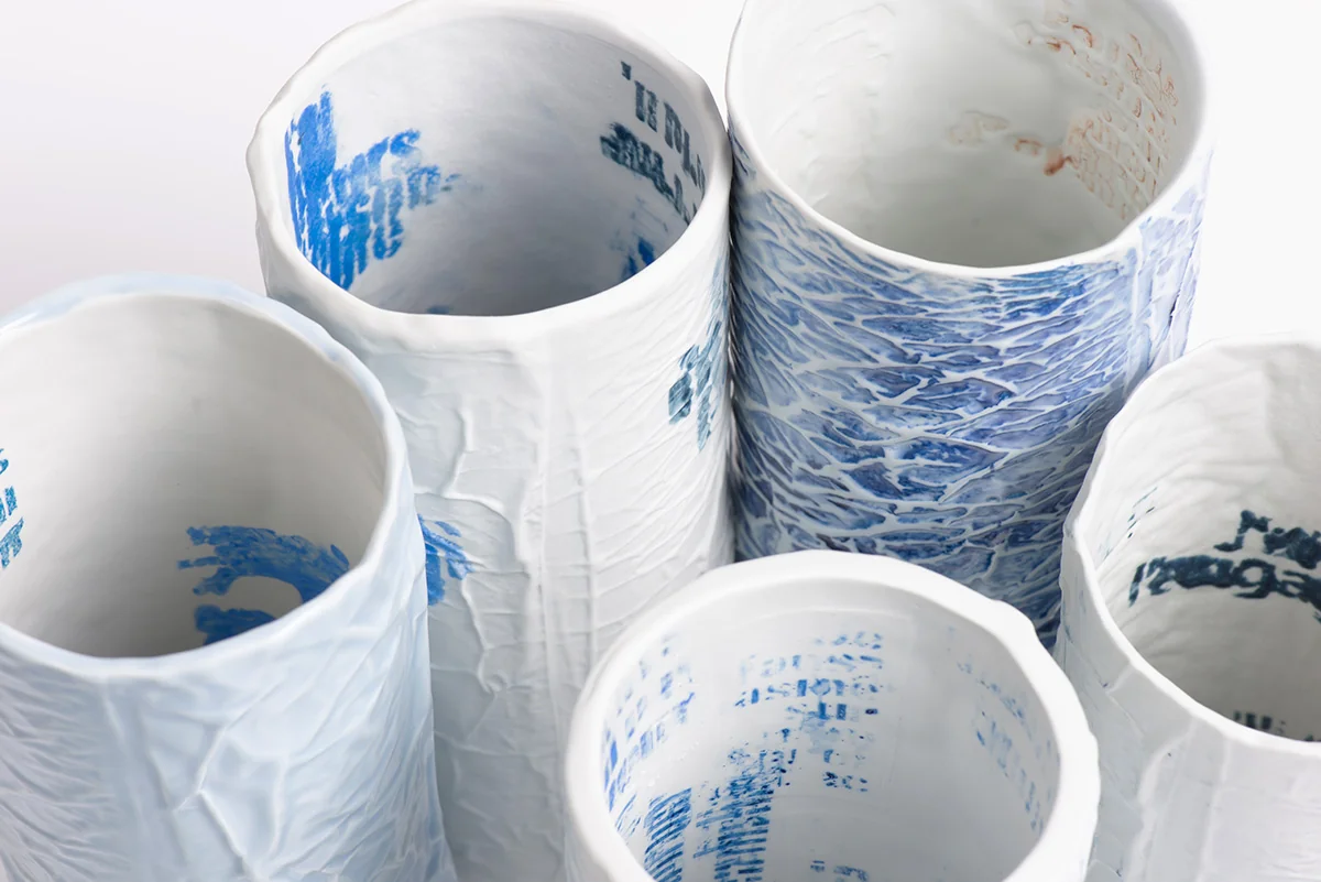 Ensemble de vases tubulaires en porcelaine froissée, écritures bleues à l’intérieur