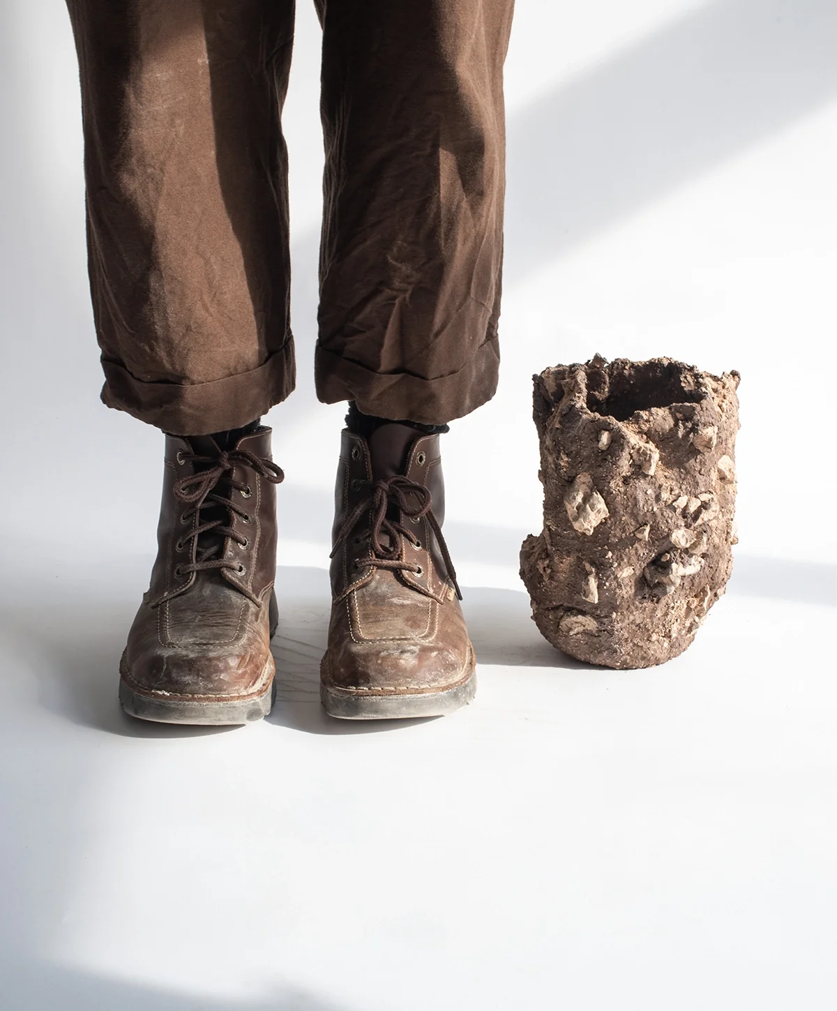 Pièce céramique posée près des chaussures de marche d’un marcheur