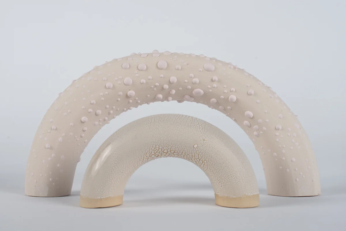 Deux arches en céramique blanche emboîtées, l’une couverte de reliefs