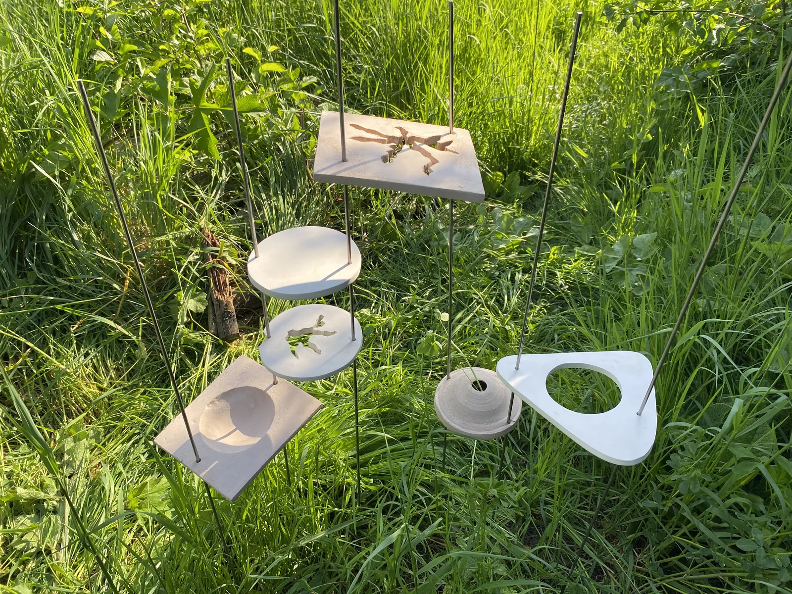 Modules en céramique installés sur des tiges métalliques dans un jardin