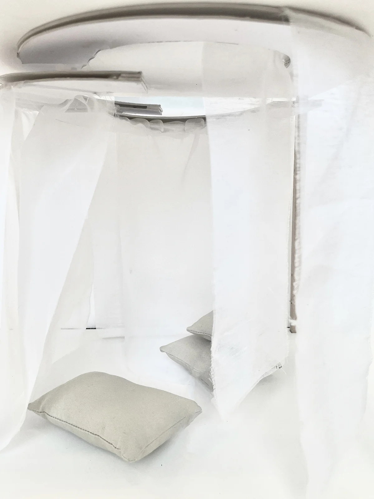 Maquette : alcôve de voiles blancs suspendus autour d’un coussin