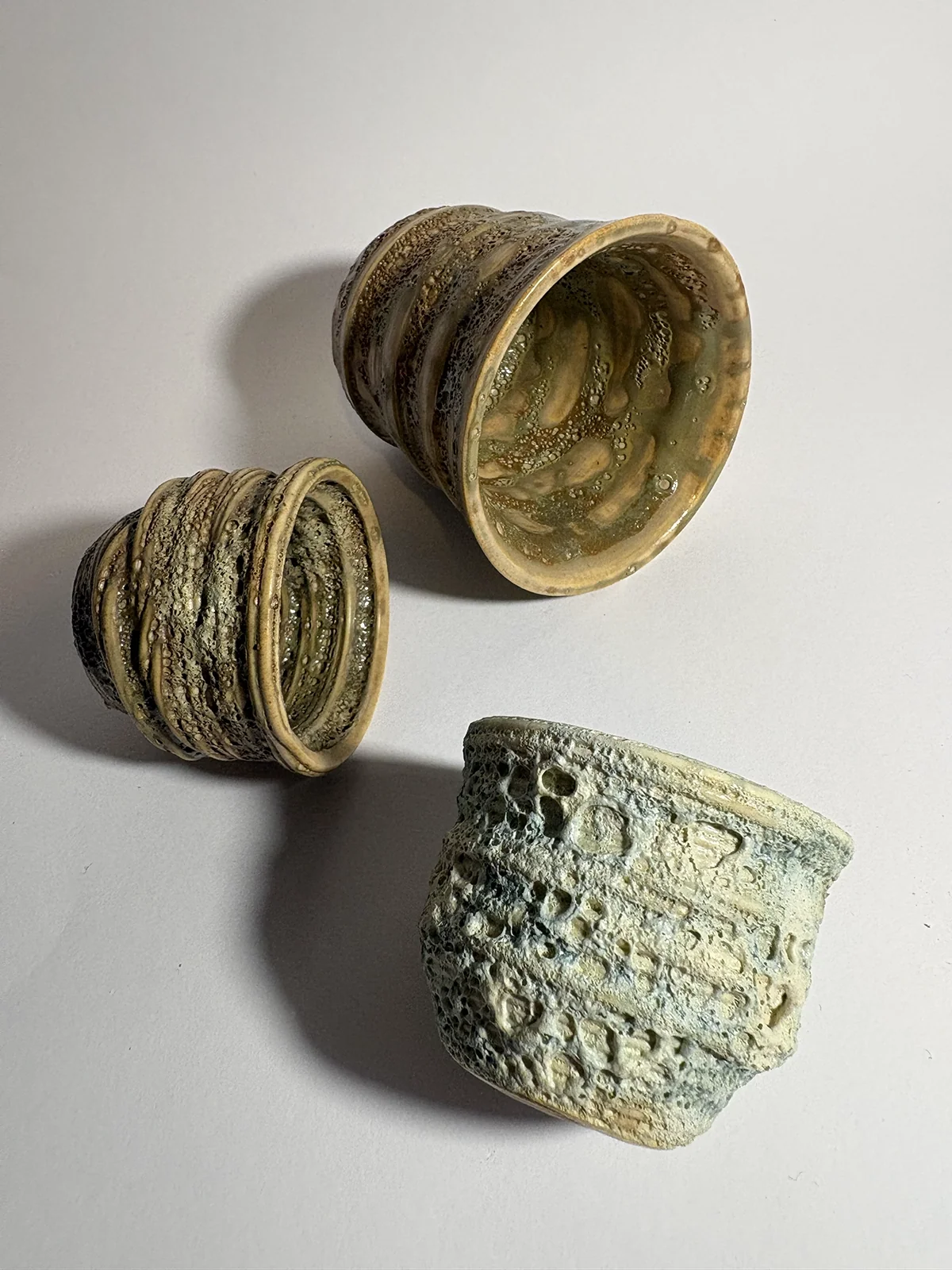 Trois pièces en céramique aux surfaces texturées, émaillées en vert et beige