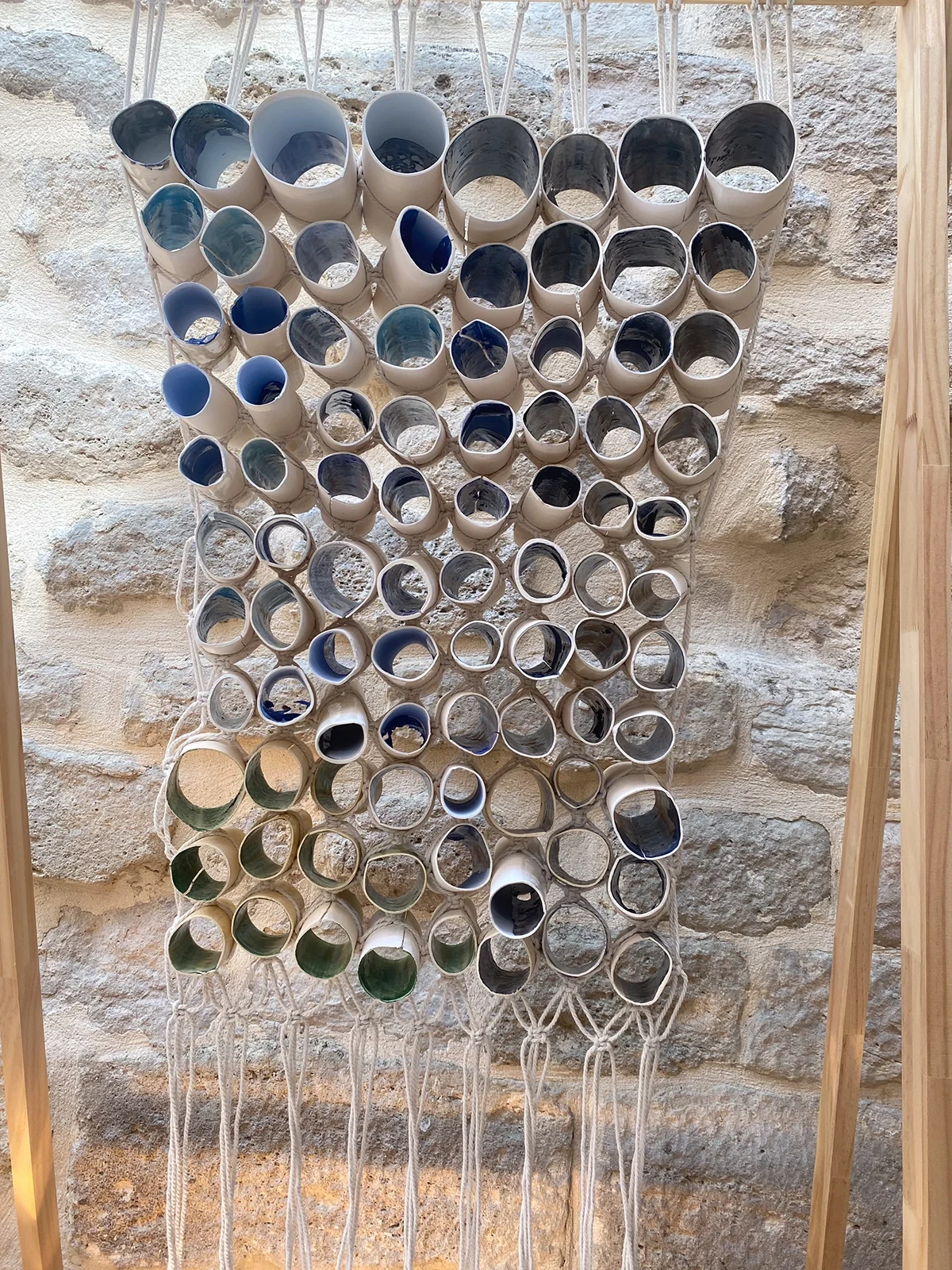 Paroi de cylindres en papier porcelaine suspendus par des cordes